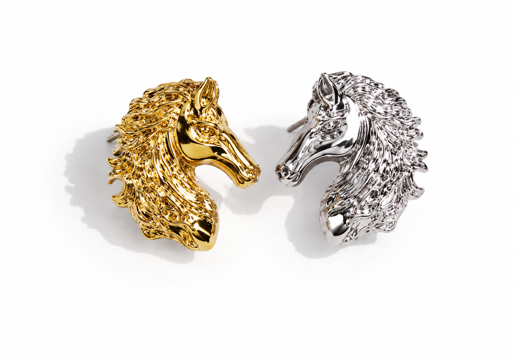 Two metallic horse head stud earrings on a white background, one in polished gold and one in polished silver.