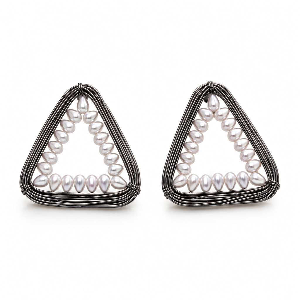 A pair of geometric triangle earrings featuring a silver-toned wire frame with a row of white baroque pearls along the inner curve, set against a plain white background.
